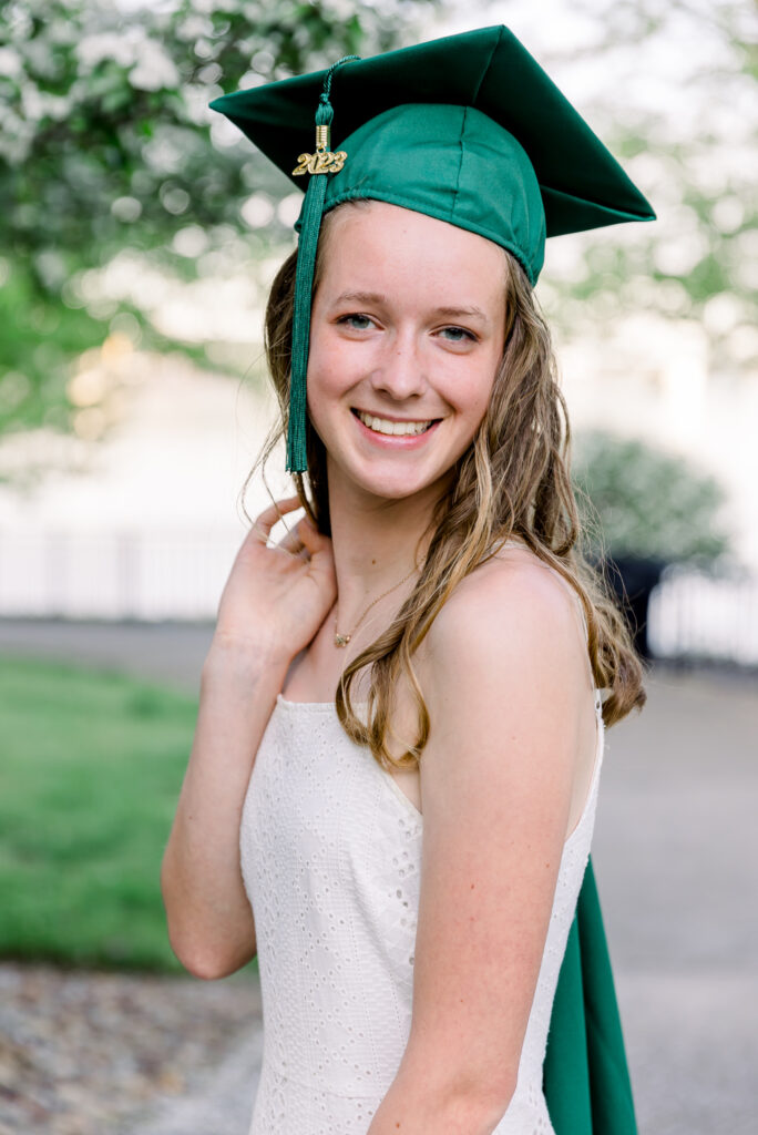 Senior girl in white dress and green cap 