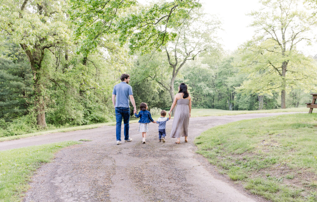 Family walking down path at park holding hands