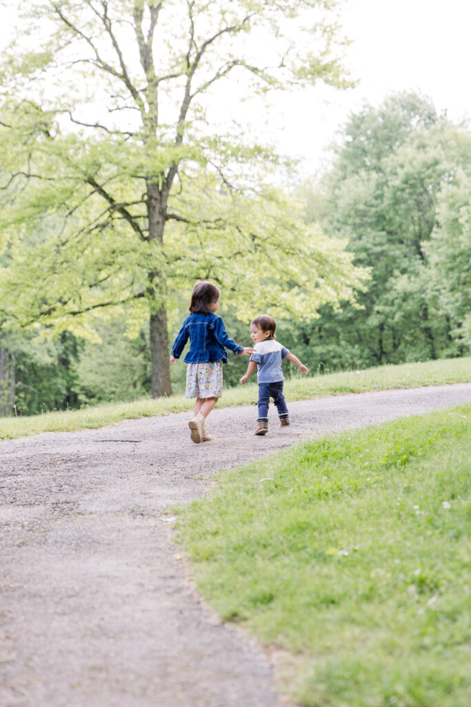 Kids running down path at park in spring photograph