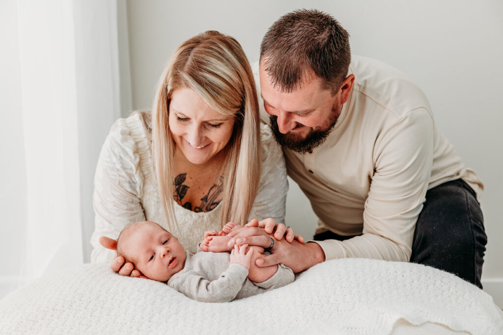 Parent holding awake newborn on bean bag during studio newborn session, Beaver PA photographer.